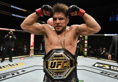 Henry Cejudo poses with the UFC belt poses for  a picture.